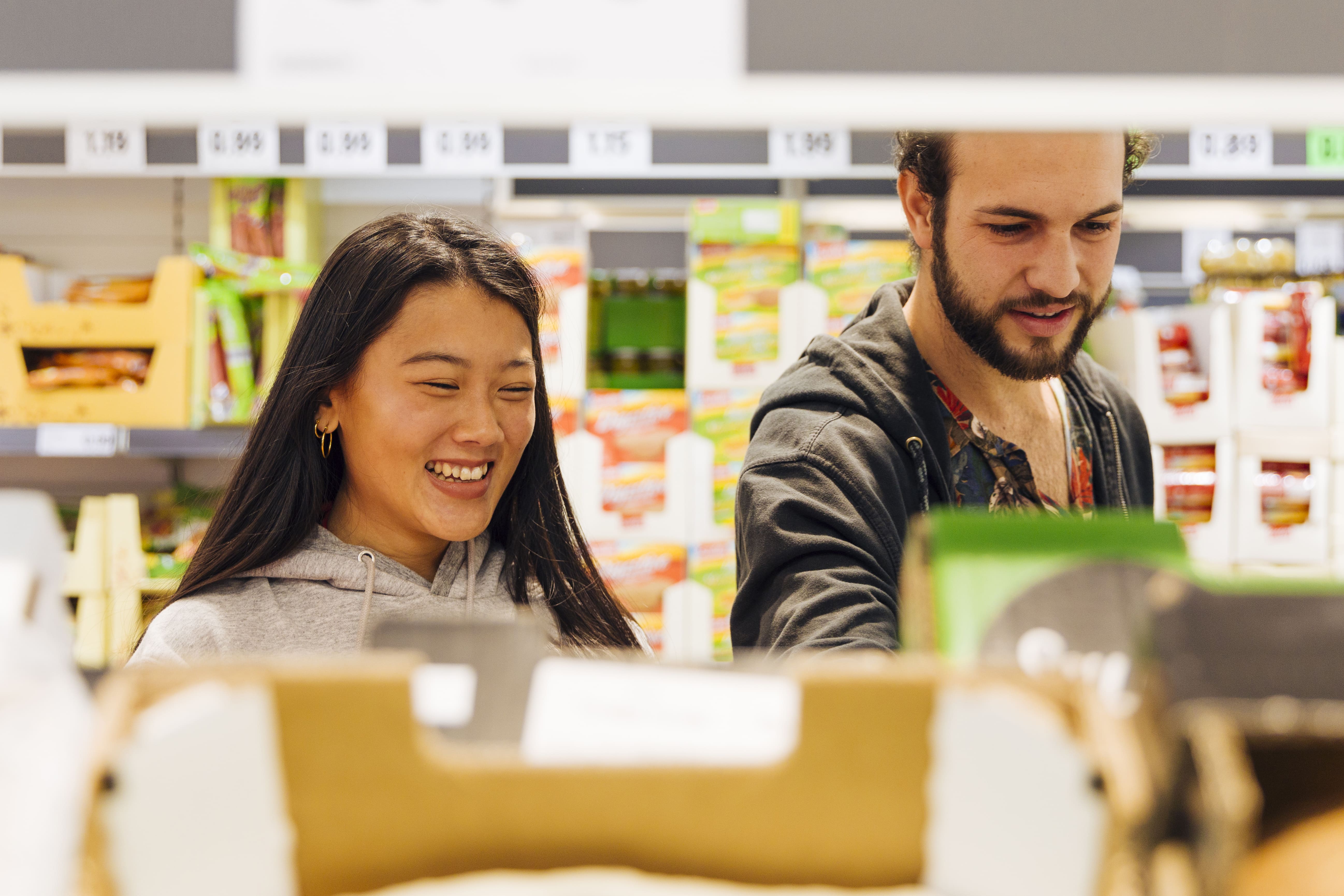 Man and woman buying food items at supermarket