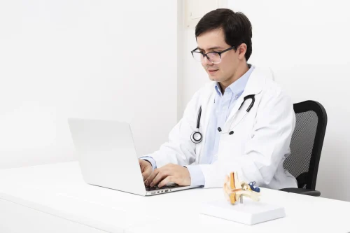 Doctor researching healthcare SEO strategies on laptop to attract more patients